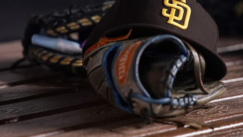 Jul 23, 2021; Miami, Florida, USA; A general view of a San Diego Padres hat and glove in the dugout prior to the game between the Miami Marlins and the San Diego Padres at loanDepot park. Mandatory Credit: Jasen Vinlove-USA TODAY Sports