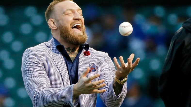 Sep 21, 2021; Chicago, Illinois, USA; MMA fighter Conor McGregor tosses the ball after throwing out a ceremonial first pitch before the game between the Chicago Cubs and the Minnesota Twins at Wrigley Field. Mandatory Credit: Jon Durr-USA TODAY Sports