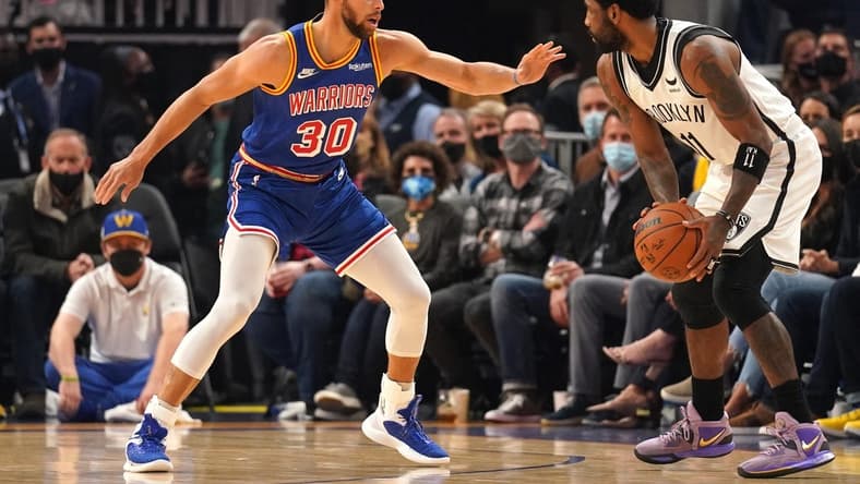 Jan 29, 2022; San Francisco, California, USA; Brooklyn Nets guard Kyrie Irving (11) controls the ball against Golden State Warriors guard Stephen Curry (30) in the first quarter at the Chase Center. Mandatory Credit: Cary Edmondson-USA TODAY Sports