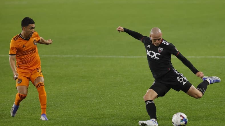May 7, 2022; Washington, District of Columbia, USA; D.C. United defender Brad Smith (5) crosses the ball as Houston Dynamo midfielder Memo Rodr guez (8) defends in the second half at Audi Field. Mandatory Credit: Geoff Burke-USA TODAY Sports