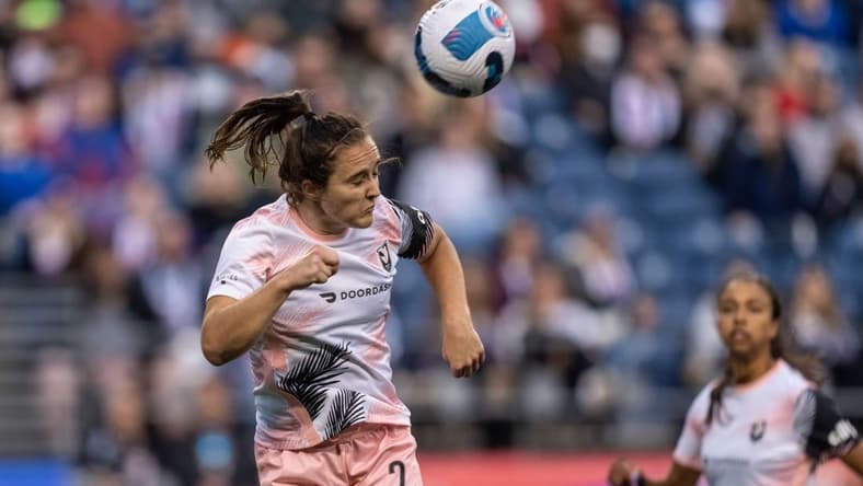 Jun 18, 2022; Seattle, Washington, USA; OL Reign midfielder Nikki Stanton (2) heads the ball against OL Reign at Lumen Field. Mandatory Credit: Stephen Brashear-USA TODAY Sports