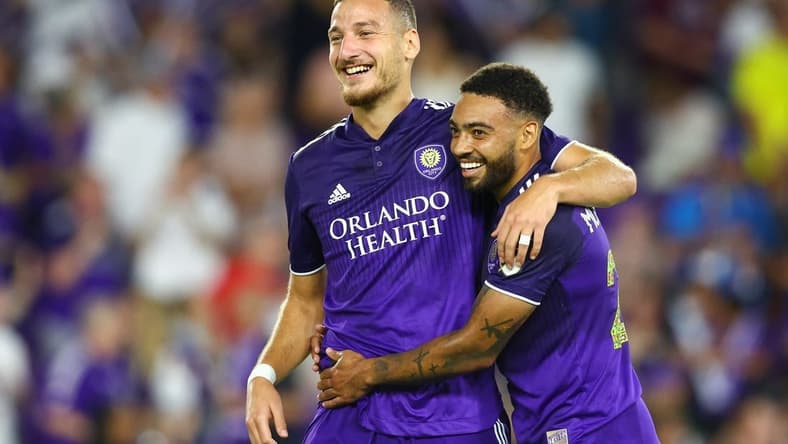 Jun 18, 2022; Orlando, Florida, USA;  Orlando City forward Ercan Kara (9) and midfielder Jake Mulraney (23) celebrate a goal against the Houston Dynamo in the second half at Exploria Stadium. Mandatory Credit: Nathan Ray Seebeck-USA TODAY Sports