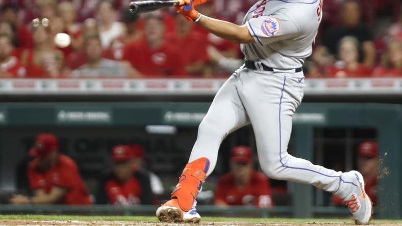Jul 6, 2022; Cincinnati, Ohio, USA; New York Mets designated hitter Dominic Smith (2) hits an RBI double against the Cincinnati Reds during the tenth inning at Great American Ball Park. Mandatory Credit: David Kohl-USA TODAY Sports