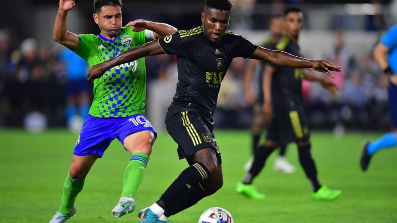 Jul 29, 2022; Los Angeles, California, USA; Los Angeles FC midfielder Daniel Crisostomo (20) moves the ball against Seattle Sounders midfielder Nicolas Lodeiro (10) during the first half at Banc of California Stadium. Mandatory Credit: Gary A. Vasquez-USA TODAY Sports