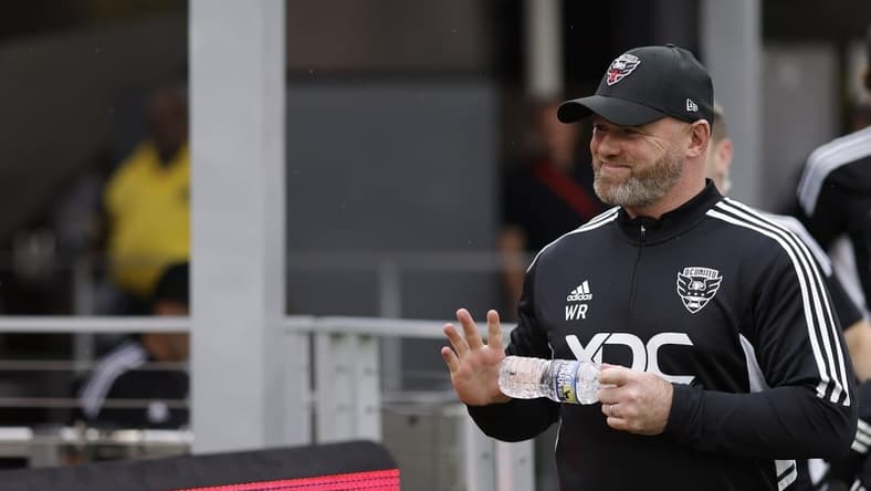 Jul 31, 2022; Washington, District of Columbia, USA; D.C. United head coach Wayne Rooney waves to fans while walking onto the pitch for his first game as head coach against Orlando City SC at Audi Field. Mandatory Credit: Geoff Burke-USA TODAY Sports