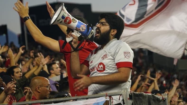 Aug 31, 2022; Toronto, Ontario, CAN; A member of a Toronto FC supporters group leads the fans in a cheer during a game against LA Galaxy at BMO Field. Mandatory Credit: John E. Sokolowski-USA TODAY Sports