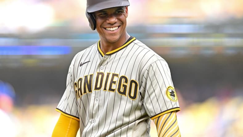 Sep 4, 2022; Los Angeles, California, USA; San Diego Padres right fielder Juan Soto (22) smiles as he talks with players in the Los Angeles Dodgers dugout in the third inning at Dodger Stadium. Mandatory Credit: Jayne Kamin-Oncea-USA TODAY Sports