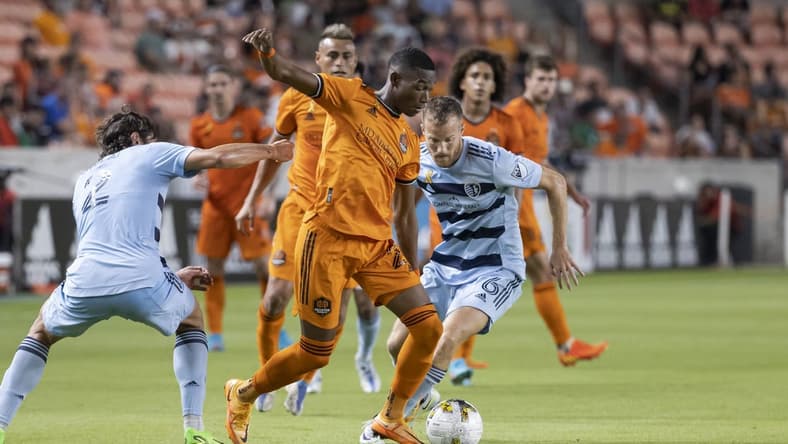 Sep 10, 2022; Houston, Texas, USA; Houston Dynamo FC forward Nelson Quinones (21) and Sporting Kansas City midfielder Uri Rosell (6) battle for the ball during the second half at PNC Stadium. Mandatory Credit: Troy Taormina-USA TODAY Sports