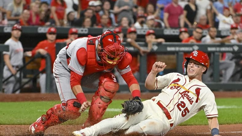 Sep 17, 2022; St. Louis, Missouri, USA; St. Louis Cardinals left fielder Corey Dickerson (25) is tagged out at home by Cincinnati Reds catcher Austin Romine (28) during the tenth inning at Busch Stadium. Mandatory Credit: Jeff Curry-USA TODAY Sports