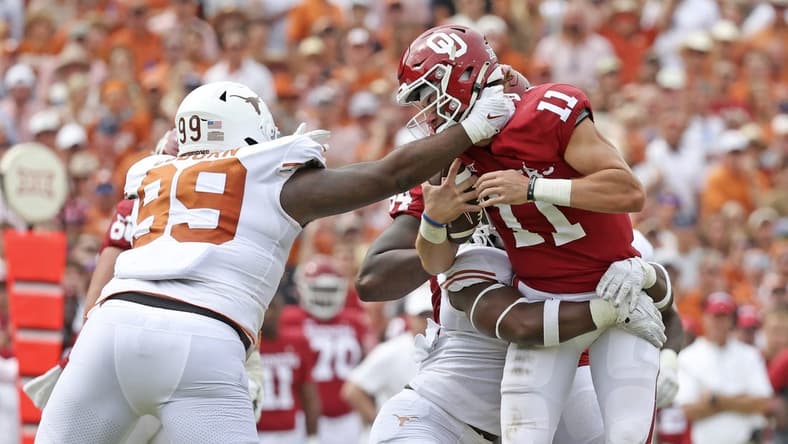 Oct 8, 2022; Dallas, Texas, USA; Texas Longhorns defensive end Justice Finkley (1) and Texas Longhorns defensive lineman Keondre Coburn (99) sack Oklahoma Sooners quarterback Davis Beville (11) during the second half at the Cotton Bowl. Mandatory Credit: Kevin Jairaj-USA TODAY Sports