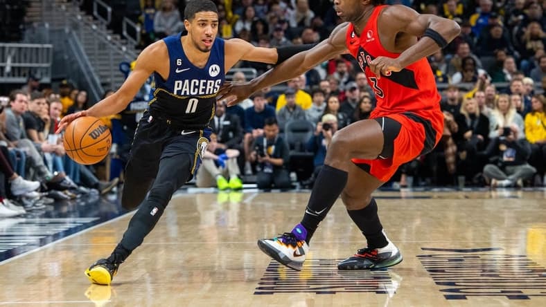 Nov 12, 2022; Indianapolis, Indiana, USA; Indiana Pacers guard Tyrese Haliburton (0) dribbles the ball while Toronto Raptors forward O.G. Anunoby (3) defends in the second half at Gainbridge Fieldhouse. Mandatory Credit: Trevor Ruszkowski-USA TODAY Sports