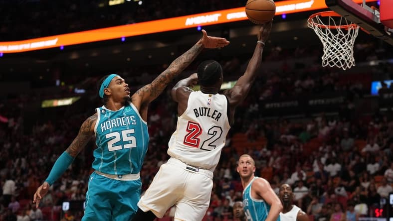 Nov 12, 2022; Miami, Florida, USA; Miami Heat forward Jimmy Butler (22) shoots the ball around Charlotte Hornets forward P.J. Washington (25) during the second half at FTX Arena. Mandatory Credit: Jasen Vinlove-USA TODAY Sports