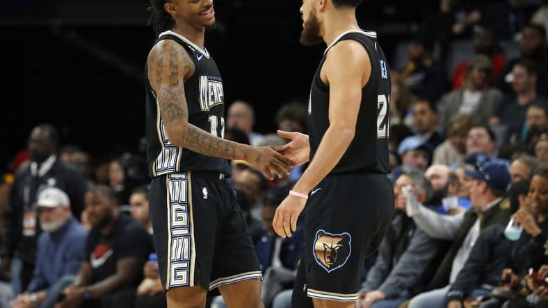 Dec 9, 2022; Memphis, Tennessee, USA; Memphis Grizzlies guard Ja Morant (12) and Memphis Grizzlies guard Tyus Jones (21) react during the second half against the Detroit Pistons at FedExForum. Mandatory Credit: Petre Thomas-USA TODAY Sports