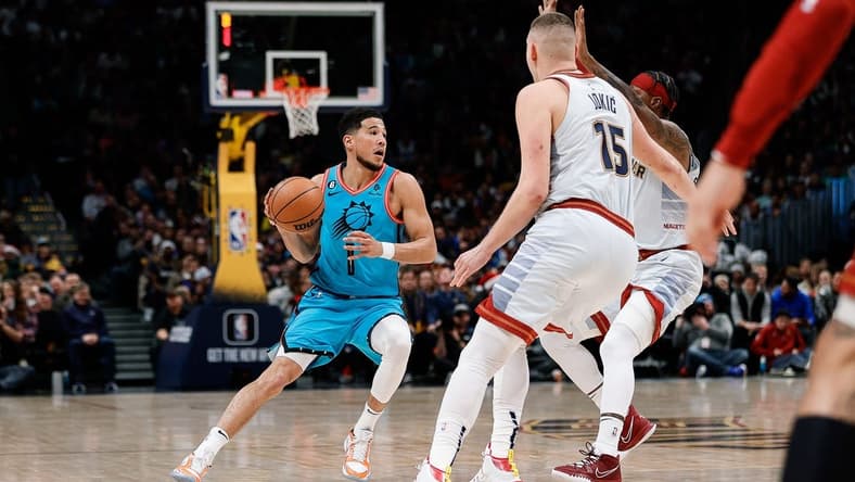 Dec 25, 2022; Denver, Colorado, USA; Phoenix Suns guard Devin Booker (1) controls the ball against Denver Nuggets center Nikola Jokic (15) and forward Zeke Nnaji (22) in the first quarter against the Phoenix Suns at Ball Arena. Mandatory Credit: Isaiah J. Downing-USA TODAY Sports