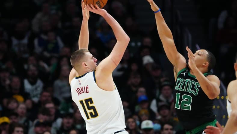 Jan 1, 2023; Denver, Colorado, USA; Denver Nuggets center Nikola Jokic (15) line up a shot over Boston Celtics forward Grant Williams (12) in the fourth quarter at Ball Arena. Mandatory Credit: Ron Chenoy-USA TODAY Sports