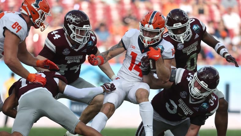 Jan 2, 2023; Tampa, FL, USA; Illinois Fighting Illini wide receiver Casey Washington (14) runs with the ball as Mississippi State Bulldogs linebacker Jett Johnson (44) and linebacker Sherman Timbs (34) defends during the first half in the 2023 ReliaQuest Bowl at Raymond James Stadium. Mandatory Credit: Kim Klement-USA TODAY Sports