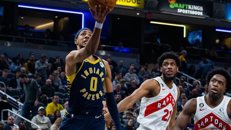 Jan 2, 2023; Indianapolis, Indiana, USA; Indiana Pacers guard Tyrese Haliburton (0) shoots the ball while Toronto Raptors forward Thaddeus Young (21)  defends in the second quarter at Gainbridge Fieldhouse. Mandatory Credit: Trevor Ruszkowski-USA TODAY Sports