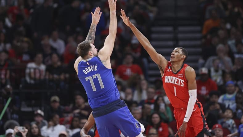 Jan 2, 2023; Houston, Texas, USA; Dallas Mavericks guard Luka Doncic (77) shoots the ball as Houston Rockets forward Jabari Smith Jr. (1) defends during the second quarter at Toyota Center. Mandatory Credit: Troy Taormina-USA TODAY Sports