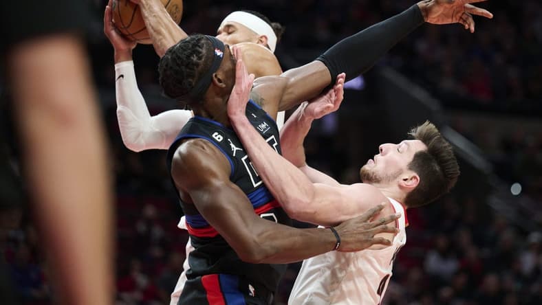 Jan 2, 2023; Portland, Oregon, USA; Detroit Pistons center Jalen Duren (0) fights for a rebound against Portland Trail Blazers forward Drew Eubanks (24) and guard Josh Hart (11) at Moda Center. Mandatory Credit: Troy Wayrynen-USA TODAY Sports