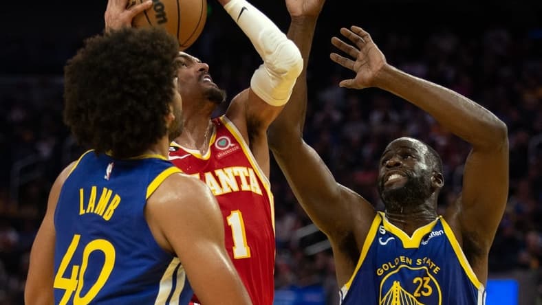 Jan 2, 2023; San Francisco, California, USA; Atlanta Hawks guard Trae Young (11) drives to the basket between Golden State Warriors forwards Anthony Lamb (40) and Draymond Green (23)  during the second quarter at Chase Center. Mandatory Credit: D. Ross Cameron-USA TODAY Sports