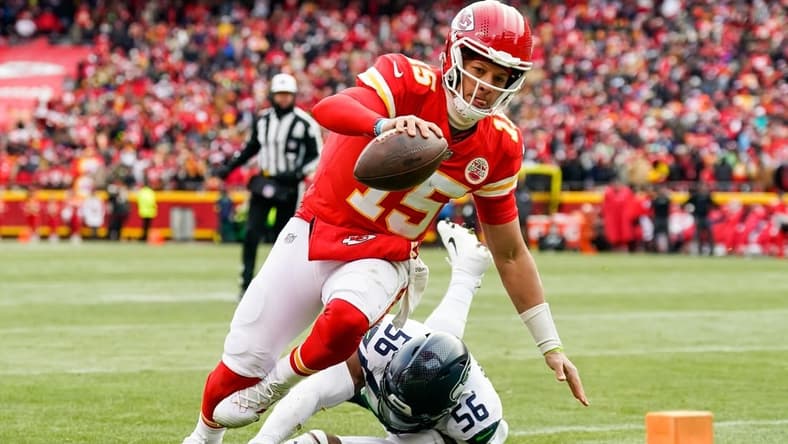 Dec 24, 2022; Kansas City, Missouri, USA; Kansas City Chiefs quarterback Patrick Mahomes (15) runs for a touchdown against Seattle Seahawks linebacker Jordyn Brooks (56) during the second half at GEHA Field at Arrowhead Stadium. Mandatory Credit: Jay Biggerstaff-USA TODAY Sports