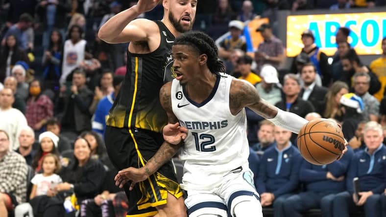 Dec 25, 2022; San Francisco, California, USA; Memphis Grizzlies guard Ja Morant (12) dribbles against Golden State Warriors guard Klay Thompson (11) during the fourth quarter at Chase Center. Mandatory Credit: Darren Yamashita-USA TODAY Sports