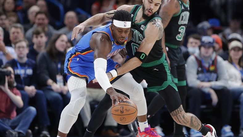 Jan 3, 2023; Oklahoma City, Oklahoma, USA; Oklahoma City Thunder guard Luguentz Dort (5) works to keep the ball away from Boston Celtics forward Jayson Tatum (0) during the first quarter at Paycom Center. Mandatory Credit: Alonzo Adams-USA TODAY Sports