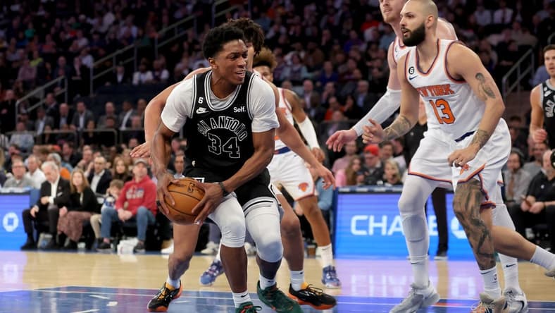 Jan 4, 2023; New York, New York, USA; San Antonio Spurs forward Stanley Johnson (34) drives to the basket against New York Knicks center Jericho Sims (45) and guard Evan Fournier (13) during the second quarter at Madison Square Garden. Mandatory Credit: Brad Penner-USA TODAY Sports