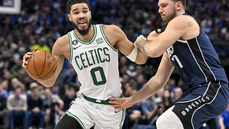 Jan 5, 2023; Dallas, Texas, USA; Boston Celtics forward Jayson Tatum (0) looks to move the ball past Dallas Mavericks guard Luka Doncic (77) during the second quarter at the American Airlines Center. Mandatory Credit: Jerome Miron-USA TODAY Sports