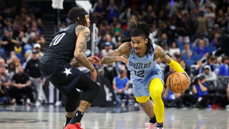 Jan 5, 2023; Orlando, Florida, USA; Memphis Grizzlies guard Ja Morant (12) drives pat Orlando Magic guard Markelle Fultz (20) in the fourth quarter at Amway Center. Mandatory Credit: Nathan Ray Seebeck-USA TODAY Sports
