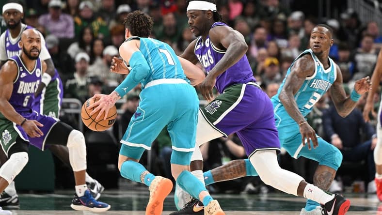 Jan 6, 2023; Milwaukee, Wisconsin, USA; Charlotte Hornets guard LaMelo Ball (1) drives against Milwaukee Bucks guard Jrue Holiday (21) in the first half at Fiserv Forum. Mandatory Credit: Michael McLoone-USA TODAY Sports