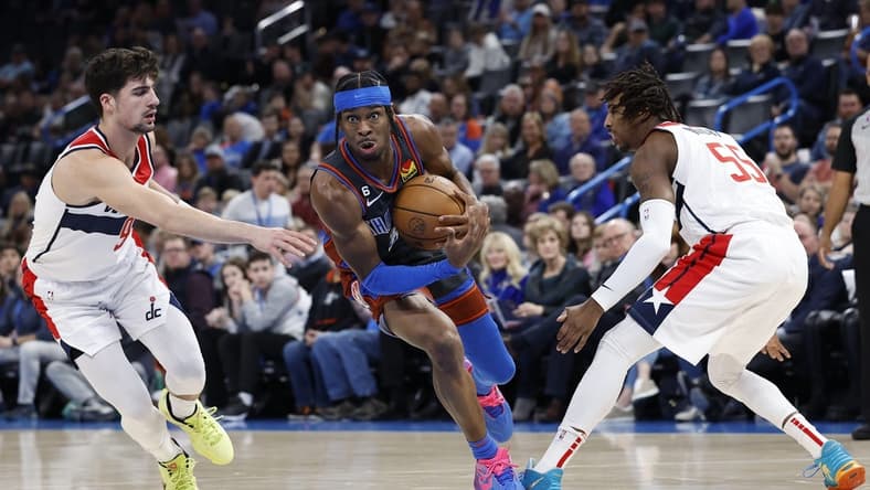 Jan 6, 2023; Oklahoma City, Oklahoma, USA; Oklahoma City Thunder guard Shai Gilgeous-Alexander (2) drives between Washington Wizards forward Deni Avdija (9) and guard Delon Wright (55) during the first quarter at Paycom Center. Mandatory Credit: Alonzo Adams-USA TODAY Sports