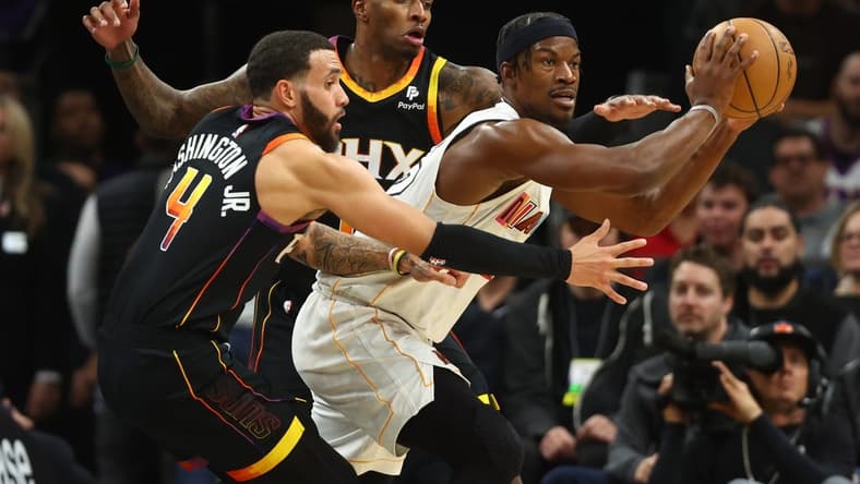 Jan 6, 2023; Phoenix, Arizona, USA; Miami Heat forward Jimmy Butler (right) moves the ball against Phoenix Suns guard Duane Washington Jr. (4) and Torrey Craig (0) in the first half at Footprint Center. Mandatory Credit: Mark J. Rebilas-USA TODAY Sports