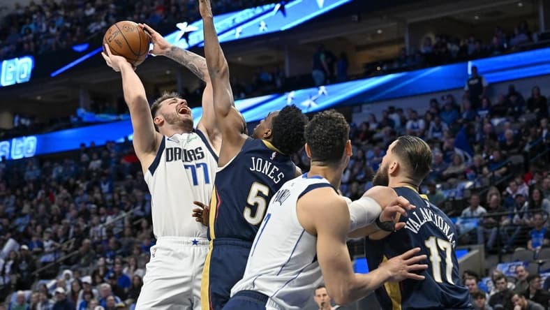 Jan 7, 2023; Dallas, Texas, USA; Dallas Mavericks guard Luka Doncic (77) shoots over New Orleans Pelicans forward Herbert Jones (5) and center Jonas Valanciunas (17) during the first quarter at the American Airlines Center. Mandatory Credit: Jerome Miron-USA TODAY Sports