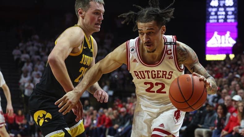 Jan 8, 2023; Piscataway, New Jersey, USA; Rutgers Scarlet Knights guard Caleb McConnell (22) dribbles against Iowa Hawkeyes forward Payton Sandfort (20) during the second half at Jersey Mike's Arena. Mandatory Credit: Vincent Carchietta-USA TODAY Sports