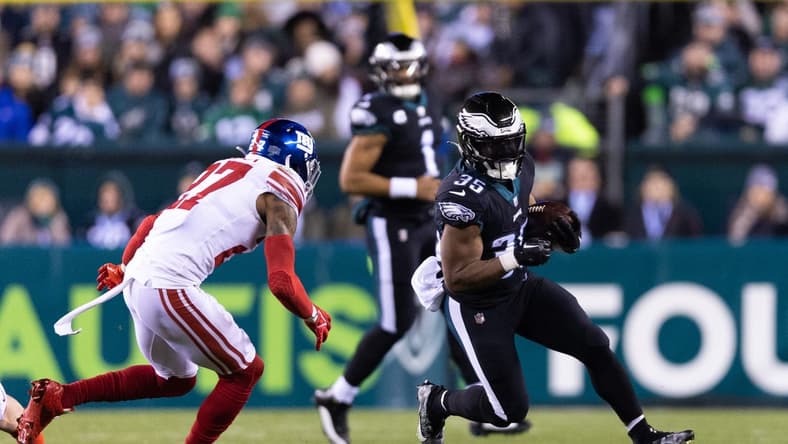 Jan 8, 2023; Philadelphia, Pennsylvania, USA; Philadelphia Eagles running back Boston Scott (35) runs with the ball against New York Giants cornerback Jason Pinnock (27) during the second quarter at Lincoln Financial Field. Mandatory Credit: Bill Streicher-USA TODAY Sports