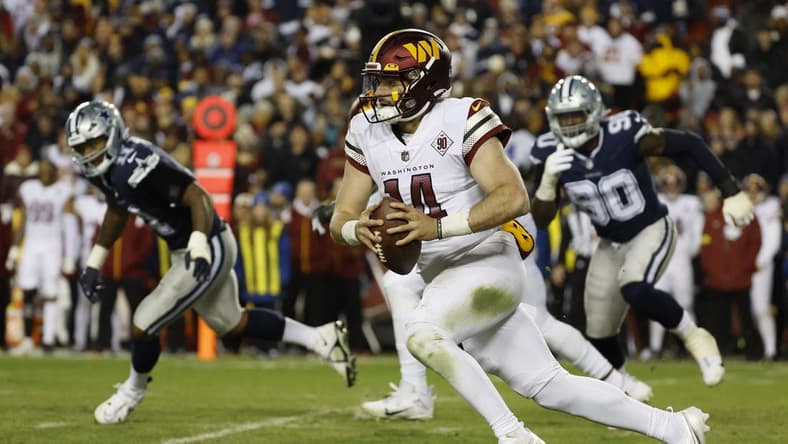 Jan 8, 2023; Landover, Maryland, USA; Washington Commanders quarterback Sam Howell (14) runs with the ball as Dallas Cowboys defensive end DeMarcus Lawrence (90) chases during the second quarter at FedExField. Mandatory Credit: Geoff Burke-USA TODAY Sports