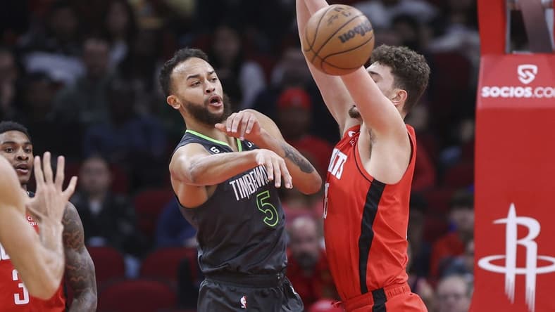 Jan 8, 2023; Houston, Texas, USA; Minnesota Timberwolves forward Kyle Anderson (5) passes the ball around Houston Rockets center Alperen Sengun (28) during the first quarter at Toyota Center. Mandatory Credit: Troy Taormina-USA TODAY Sports