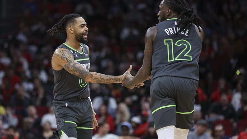 Jan 8, 2023; Houston, Texas, USA; Minnesota Timberwolves forward Taurean Prince (12) celebrates with guard D'Angelo Russell (0) after scoring a basket during the fourth quarter against the Houston Rockets at Toyota Center. Mandatory Credit: Troy Taormina-USA TODAY Sports