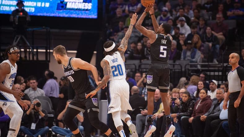 Jan 9, 2023; Sacramento, California, USA; Sacramento Kings guard De'Aaron Fox (5) takes a three point shot over Orlando Magic guard Markelle Fultz (20) during the first quarter at Golden 1 Center. Mandatory Credit: Ed Szczepanski-USA TODAY Sports