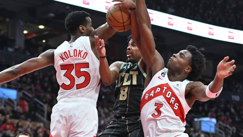 Jan 10, 2023; Toronto, Ontario, CAN; Charlotte Hornets guard Dennis Smith Jr. (8) has his shot attempt blocked by Toronto Raptors center Christian Koloko (35) and forward OG Anunoby (3) in the first half at Scotiabank Arena. Mandatory Credit: Dan Hamilton-USA TODAY Sports