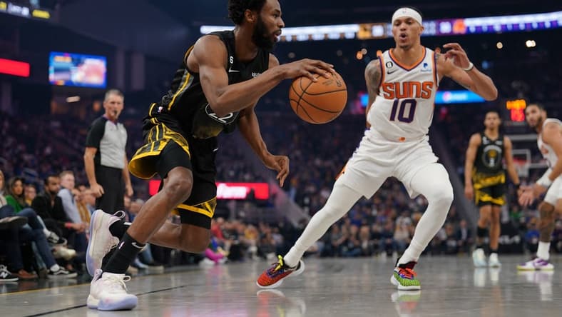 Jan 10, 2023; San Francisco, California, USA; Golden State Warriors forward Andrew Wiggins (22) dribbles past Phoenix Suns guard Damion Lee (10) in the second quarter at the Chase Center. Mandatory Credit: Cary Edmondson-USA TODAY Sports