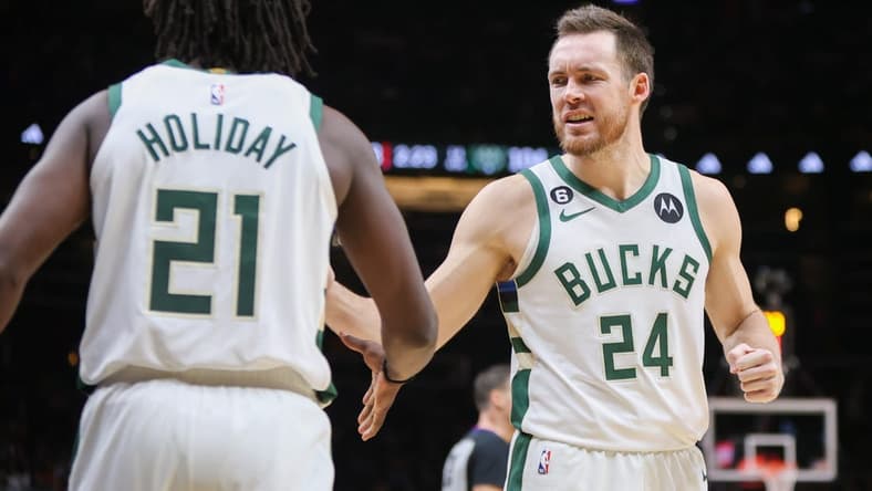 Jan 11, 2023; Atlanta, Georgia, USA; Milwaukee Bucks guard Pat Connaughton (24) reacts with guard Jrue Holiday (21) against the Atlanta Hawks in the second half at State Farm Arena. Mandatory Credit: Brett Davis-USA TODAY Sports