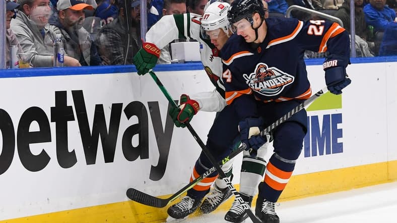 Jan 12, 2023; Elmont, New York, USA;  Minnesota Wild left wing Kirill Kaprizov (97) and New York Islanders defenseman Scott Mayfield (24) battle for the puck behind the net during the first period at UBS Arena. Mandatory Credit: Dennis Schneidler-USA TODAY Sports