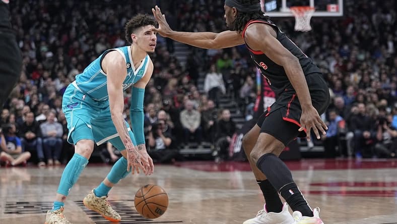 Jan 12, 2023; Toronto, Ontario, CAN; Toronto Raptors forward Precious Achiuwa (5) defends against Charlotte Hornets guard LaMelo Ball (1) during the first half at Scotiabank Arena. Mandatory Credit: John E. Sokolowski-USA TODAY Sports