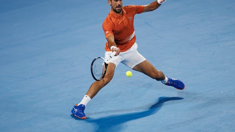 Jan 13, 2023; Melbourne, Victoria, Australia; Novak Djokovic of Serbia hits a shot during an exhibition practice match against Nick Kyrgios of Australia on Rod Laver Arena at Melbourne Park. Mandatory Credit: Mike Frey-USA TODAY Sports