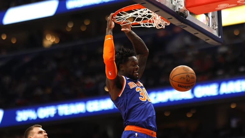 Jan 13, 2023; Washington, District of Columbia, USA; New York Knicks forward Julius Randle (30) dunks the ball as Washington Wizards center Kristaps Porzingis (6) looks on in the first quarter at Capital One Arena. Mandatory Credit: Geoff Burke-USA TODAY Sports