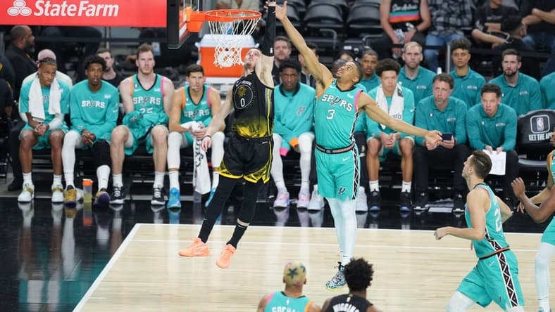 Jan 13, 2023; San Antonio, Texas, USA; Golden State Warriors guard Donte DiVincenzo (0) shoots in front of San Antonio Spurs forward Keldon Johnson (3) in the second half at the Alamodome. Mandatory Credit: Daniel Dunn-USA TODAY Sports