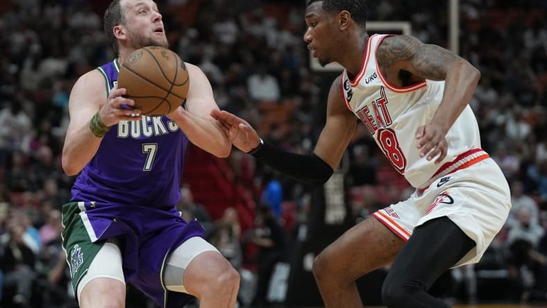 Jan 14, 2023; Miami, Florida, USA; Milwaukee Bucks guard Joe Ingles (7) shoots the ball against Miami Heat forward Jamal Cain (8) during the first half at Miami-Dade Arena. Mandatory Credit: Jim Rassol-USA TODAY Sports