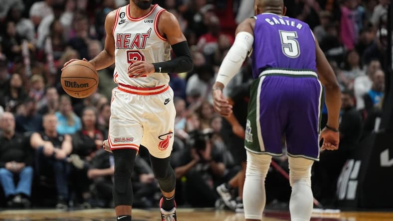 Jan 14, 2023; Miami, Florida, USA; Miami Heat guard Gabe Vincent (2) brings the ball up the court against Milwaukee Bucks guard Jevon Carter (5) during the second half at Miami-Dade Arena. Mandatory Credit: Jim Rassol-USA TODAY Sports